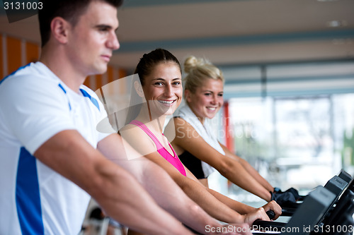 Image of friends  exercising on a treadmill at the bright modern gym