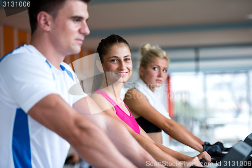 Image of friends  exercising on a treadmill at the bright modern gym