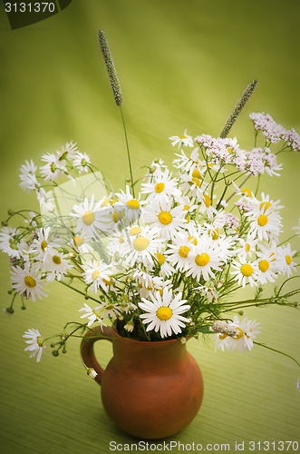 Image of Bouquet of wild flowers in a clay pot, close-up  