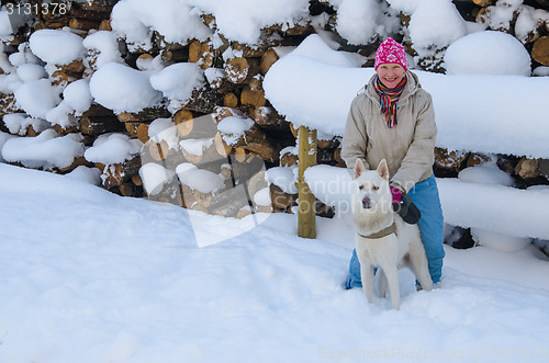 Image of The woman with a dog on walk in a winter wood