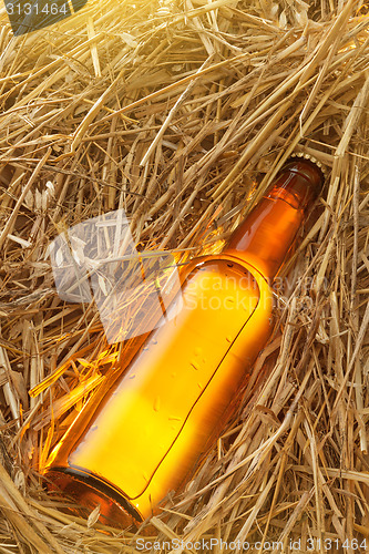 Image of Beer bottle in the stack of hay