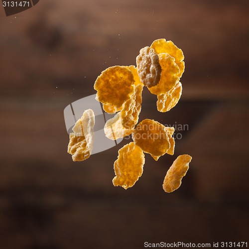 Image of Falling corn flakes on wooden background