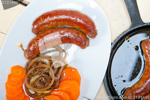 Image of beef sausages cooked on iron skillet 