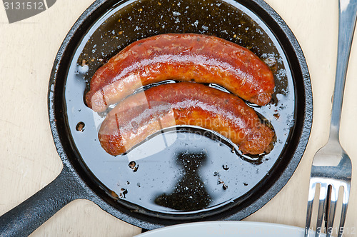 Image of beef sausages cooked on iron skillet 