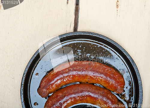 Image of beef sausages cooked on iron skillet 