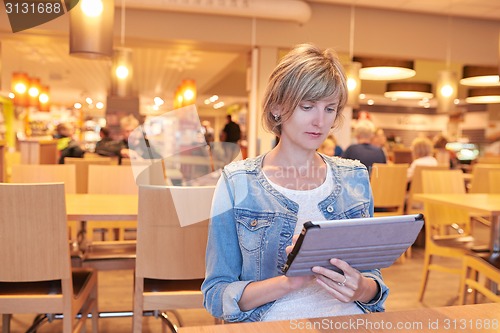 Image of Woman sitting in the cafe using digital tablet