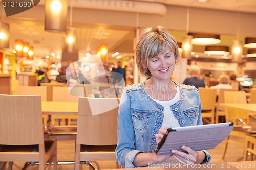 Image of Woman sitting in the cafe using digital tablet