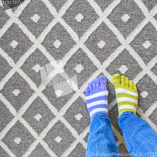 Image of Legs in mismatched socks on gray carpet