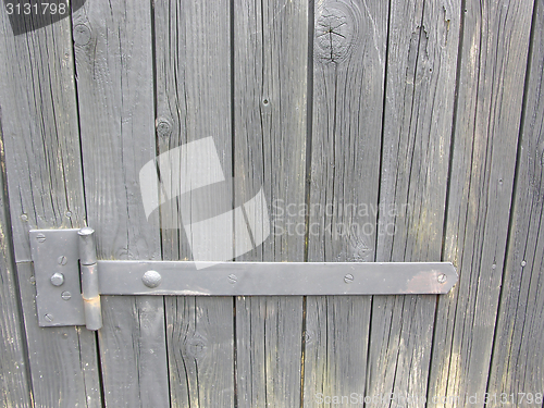 Image of The iron door hinge of a wooden shelter