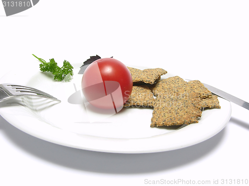 Image of Tomato with hand make crisp bread on a white plate