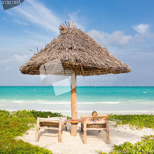 Image of Woman sunbathing on tropical beach.