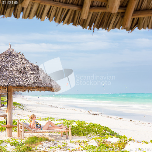 Image of Woman sunbathing on tropical beach.