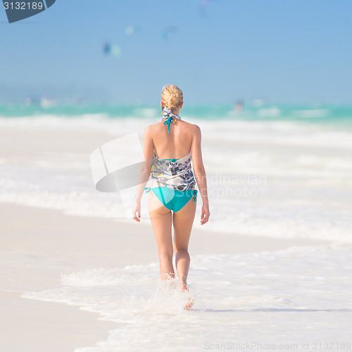 Image of Woman walking on the beach.