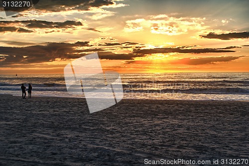 Image of Happy couple walking on the beach at sunrise for holiday time