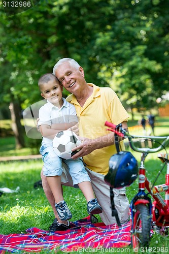 Image of grandfather and child have fun  in park