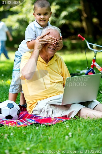 Image of grandfather and child using laptop