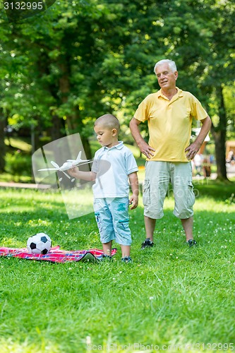 Image of grandfather and child have fun  in park