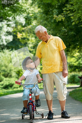 Image of grandfather and child have fun  in park