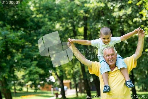 Image of grandfather and child have fun  in park