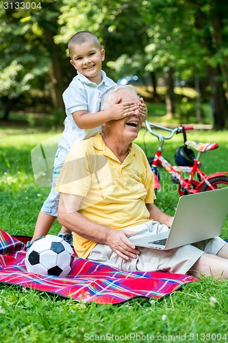 Image of grandfather and child using laptop