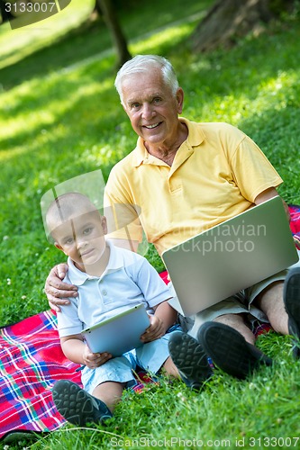 Image of grandfather and child using laptop