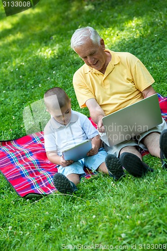 Image of grandfather and child using laptop