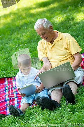 Image of grandfather and child using laptop