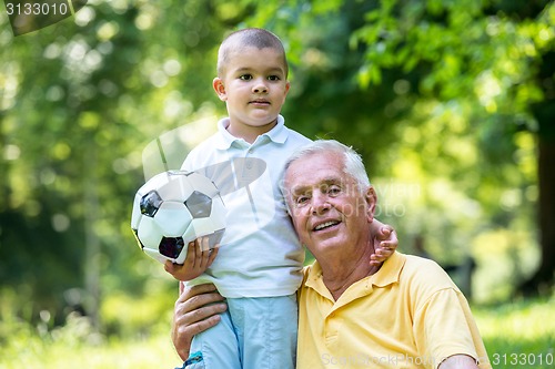 Image of grandfather and child have fun  in park