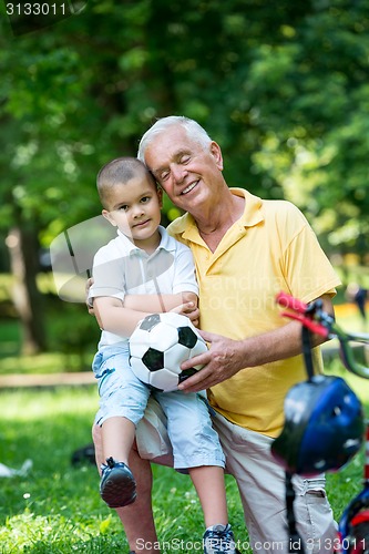 Image of grandfather and child have fun  in park