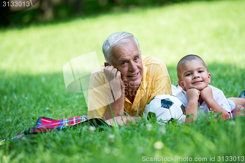 Image of grandfather and child have fun  in park