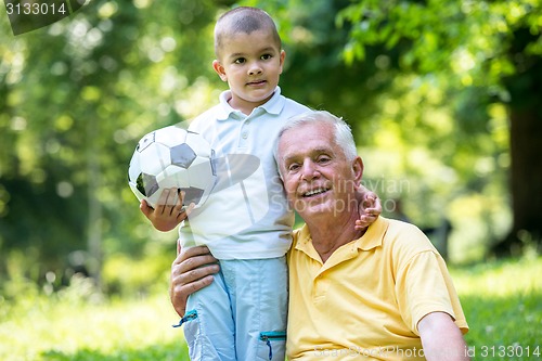 Image of grandfather and child have fun  in park