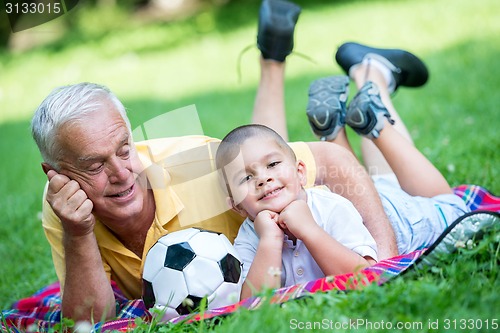 Image of grandfather and child have fun  in park