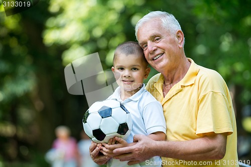 Image of grandfather and child have fun  in park