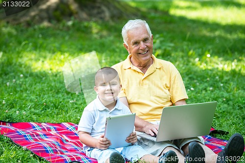 Image of grandfather and child using laptop