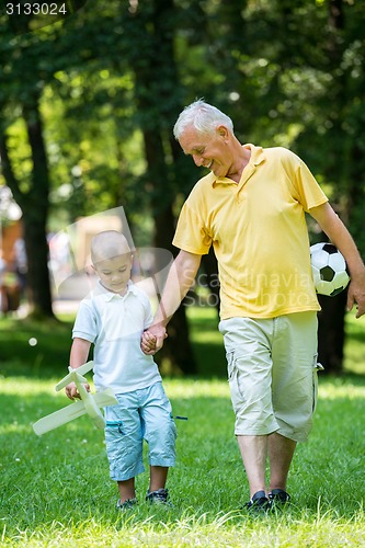 Image of grandfather and child have fun  in park