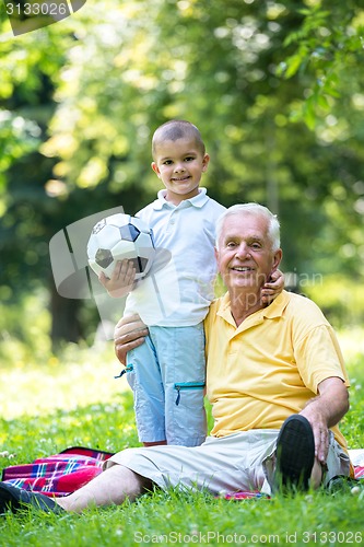 Image of grandfather and child have fun  in park