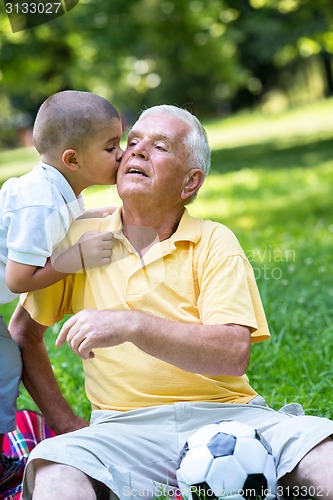 Image of grandfather and child have fun  in park