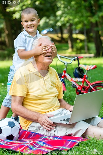 Image of grandfather and child using laptop