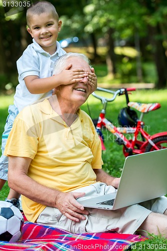 Image of grandfather and child using laptop