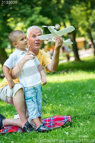 Image of grandfather and child have fun  in park