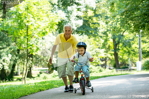 Image of grandfather and child have fun  in park