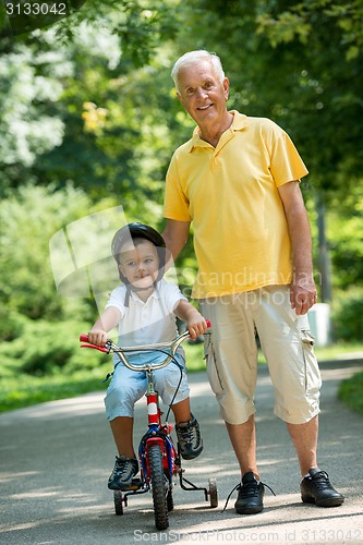 Image of grandfather and child have fun  in park