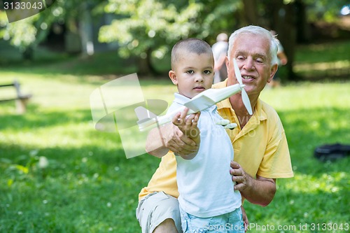 Image of grandfather and child have fun  in park