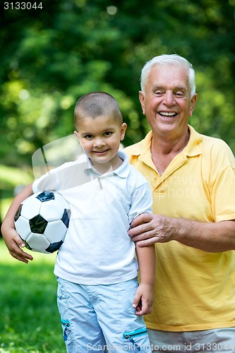 Image of grandfather and child have fun  in park