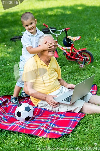 Image of grandfather and child using laptop