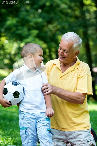 Image of grandfather and child have fun  in park