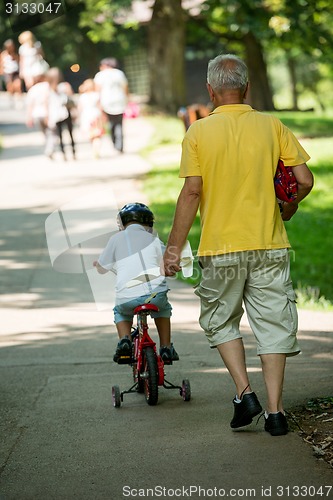 Image of grandfather and child have fun  in park