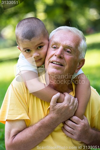 Image of grandfather and child have fun  in park