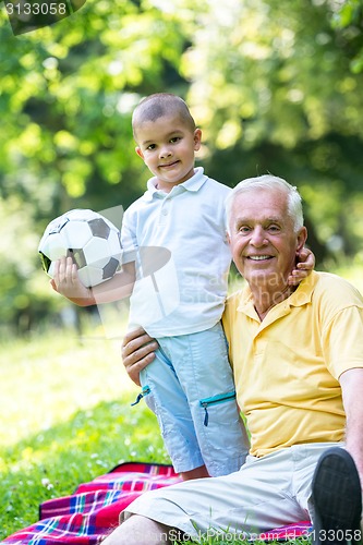 Image of grandfather and child have fun  in park