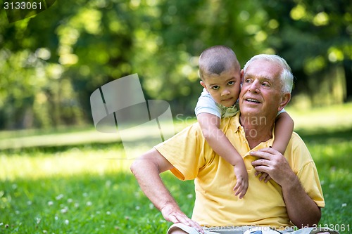 Image of grandfather and child have fun  in park